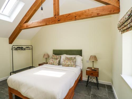 a bedroom with a bed and a wooden ceiling at Llety Cariad - 2 Plough & Harrow in Cowbridge