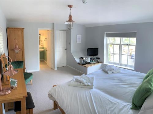 Ferryman`s Cottage at The Beetle & Wedge في Moulsford: غرفة نوم عليها سرير وفوط