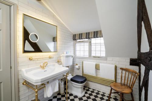 a bathroom with a sink and a toilet and a mirror at The Pheasant Inn in Higher Burwardsley