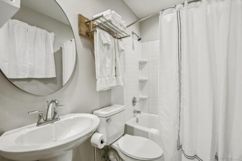 La salle de bains est pourvue d'un lavabo, de toilettes et d'un miroir. dans l'établissement Whiskey on the River, à Petal