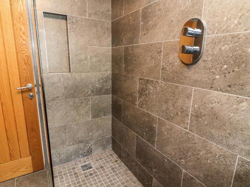 a bathroom with a shower with a glass door at Corner Cottage in Sedbergh