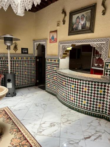 Habitación con pared de azulejos y chimenea. en Riad Elijah Marrakech & Spa, en Marrakech