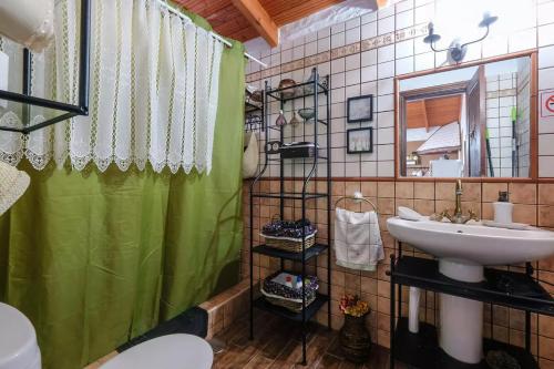 a bathroom with a green shower curtain and a sink at Casa Olympia, Tamaimo in Tamaimo