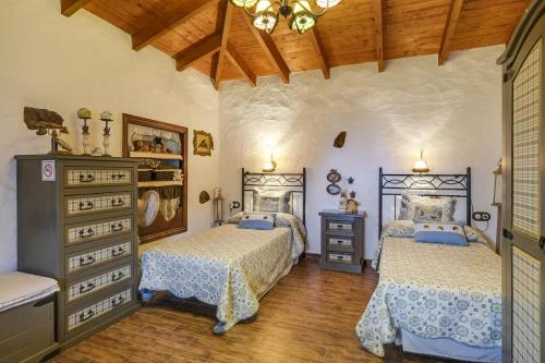 a bedroom with two beds and a wooden floor at Casa Olympia, Tamaimo in Tamaimo