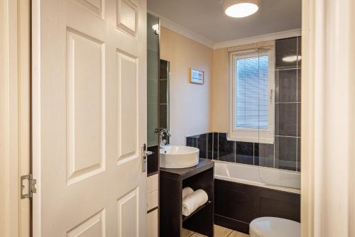 a bathroom with a sink and a toilet and a tub at Lakeland Lodge in Carnforth