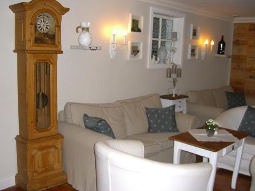a living room with a couch and a grandfather clock at Villa Bucher - Metnitztalerhof in Friesach
