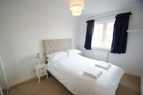 1 dormitorio con cama blanca y ventana en Cosy Family Home Near the Quay, en Exeter