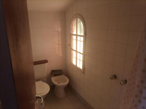 a bathroom with a toilet and a window at Cabañas Akumali in Nono