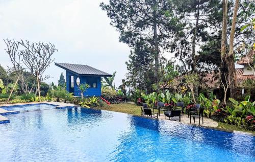 a swimming pool in a yard with chairs and a house at Cottonwood Exclusive Villa @Lembang Asri - Jacuzzi Playground Netflix Billyard in Lembang