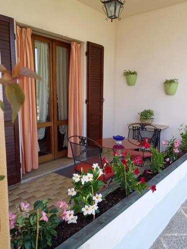 eine Terrasse mit Blumen, einem Tisch und Stühlen in der Unterkunft B & B Cedro Argentato in Legnago