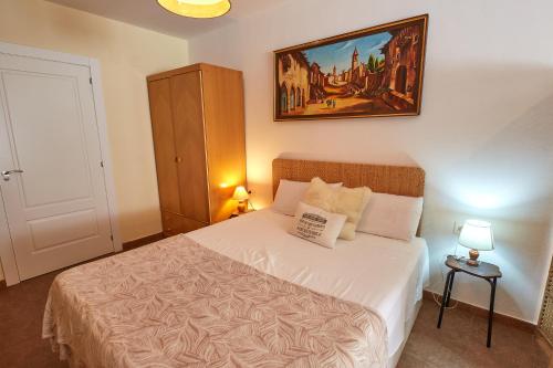 a bedroom with a bed with a painting on the wall at Apartahotel Belchite in Belchite