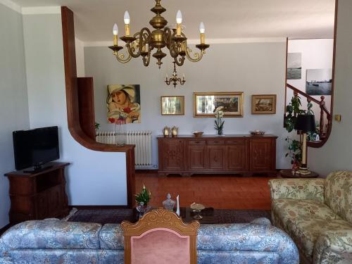 un soggiorno con divano e lampadario pendente di B & B Cedro Argentato a Legnago