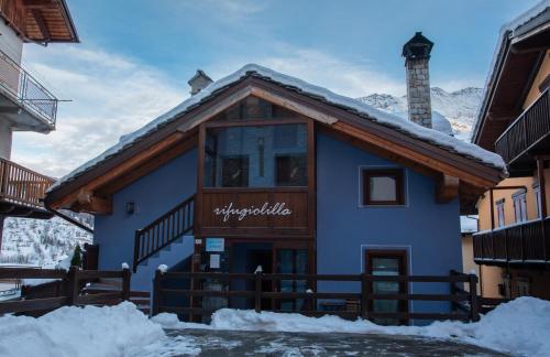 a blue building with snow on the ground at Rifugio Lilla in La Thuile
