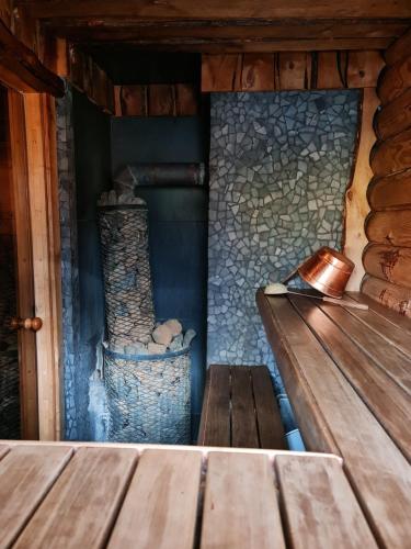 a wooden bench in a cabin with a stone wall at NPLIHOUSE in Otepää