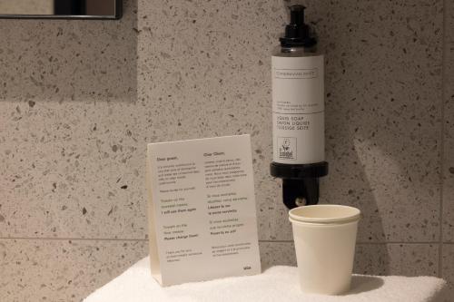 a bottle of alcohol and a coffee cup on a counter at Hôtel de France Gare de Lyon Bastille in Paris