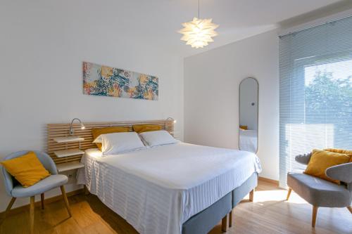 a bedroom with a bed and a desk and chairs at Maison BOOA in Sévrier