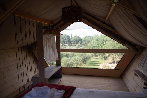 a bedroom with a large window in a tent at Agriturismo Podere Prataccio in Scansano
