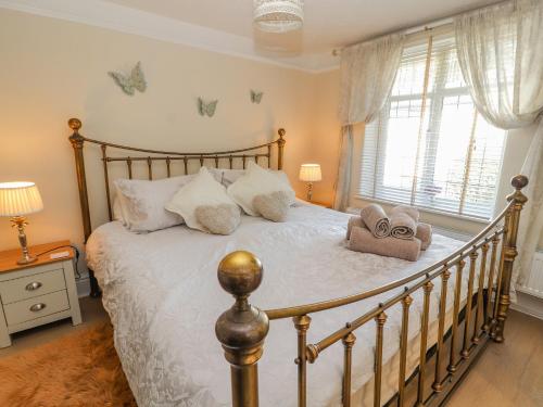 a bedroom with a large bed with white sheets and pillows at Llidiart Cerrig in Dyserth