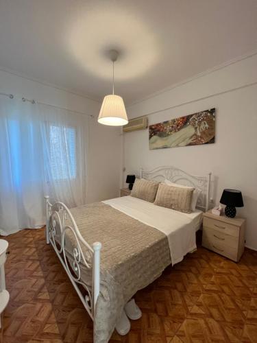a bedroom with a white bed and a lamp at Modern apartment in the heart of Athens. in Athens