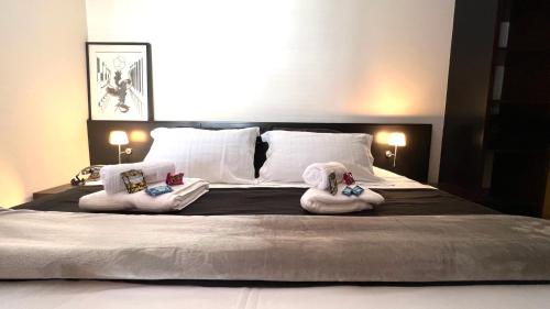 Dos toallas en una cama con dos animales de peluche. en 103 - Rentaqui - Flat Apartamento Opera Confort no Jardins, en São Paulo
