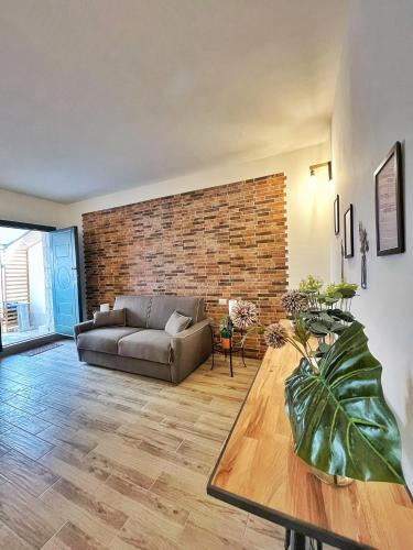 ein Wohnzimmer mit Sofa und Ziegelwand in der Unterkunft Ingrosso house Mini loft Lecce in Lecce