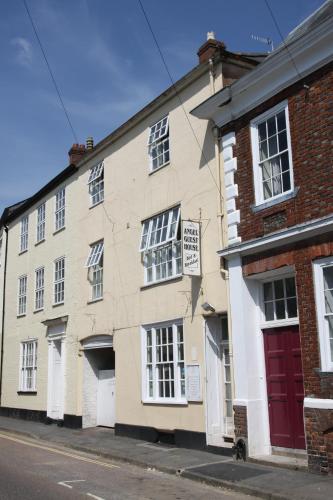 a brick building with a red door on a street at Angel Guesthouse in Tiverton