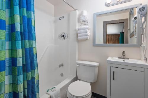 a bathroom with a toilet and a sink and a mirror at Beach Bum Inn in Ocean City