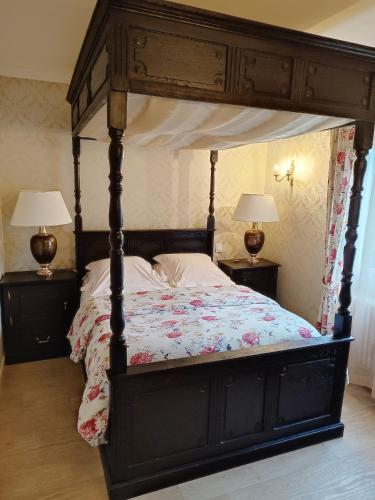 a bedroom with a canopy bed with two lamps at l'Auberge des Gourmets Hôtel Restaurant in Le Vaudioux