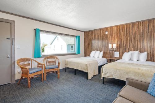 um quarto de hotel com duas camas e uma mesa e cadeiras em Beach Bum Inn em Ocean City