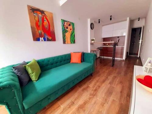 a green couch sitting in a living room at Limone apartmani Niš in Niš