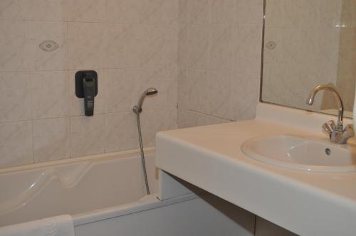 a bathroom with a phone on the wall next to a sink at Hotel La Terrasse in Fort-Mahon-Plage