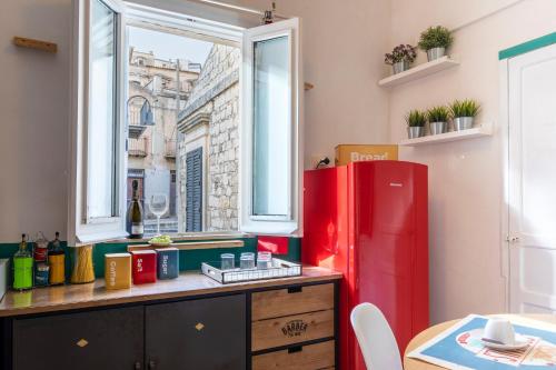 a kitchen with a red refrigerator and a window at Misar-36 in Modica