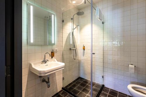 een badkamer met een wastafel en een douche bij Bistrotel 't Amsterdammertje in Nieuwersluis