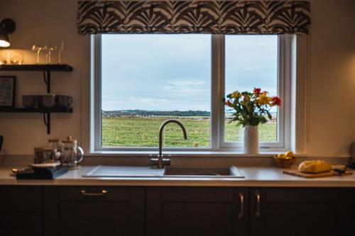 a kitchen window with a view of a field at Drumdry in Wick