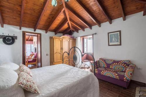 a bedroom with a large bed and a chair at Casa Mercedes, Tamaimo in Tamaimo