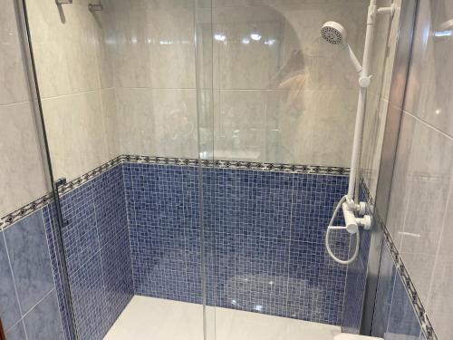 La salle de bains est pourvue d'une douche et de carrelage bleu. dans l'établissement Las Salinas, à Roquetas de Mar