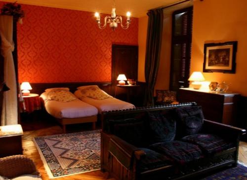 a bedroom with two beds and a couch and a chair at Château de la Grange Fort in Issoire