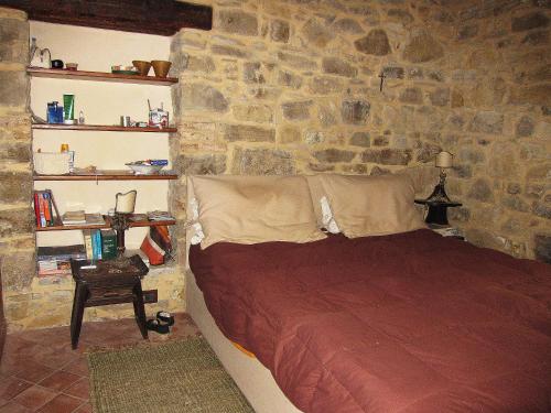 een slaapkamer met een bed in een stenen muur bij Villa Degli Ulivi in Collesano