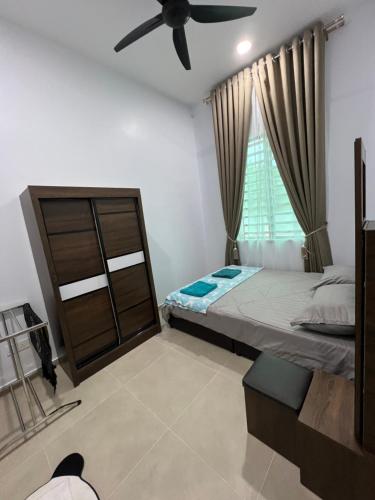 1 dormitorio con 1 cama y ventilador de techo en Homestay SJTM, en Cukai