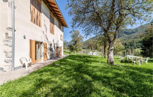 a house with a green lawn next to a building at Stunning Home In Ledro With Wifi in Ledro