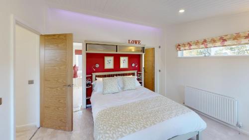 um quarto com uma grande cama branca e uma janela em Beech 27 Hot Tub em Garton