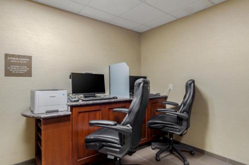 an office with a desk with a computer and chairs at Comfort Suites Pflugerville - Austin North in Pflugerville