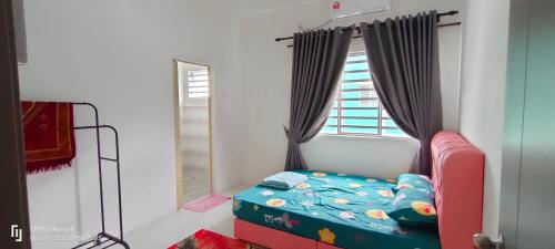 a bedroom with a bed and a window at RAYYAN HOMESTAY SERI ISKANDAR PERAK in Kampong Bota Road