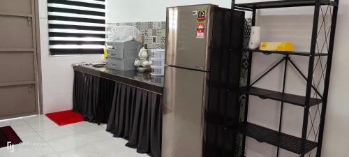a kitchen with a refrigerator and a black shelf at Rayyan Homestay Seri Iskandar Perak Near Utp Uitm in Kampong Bota Road