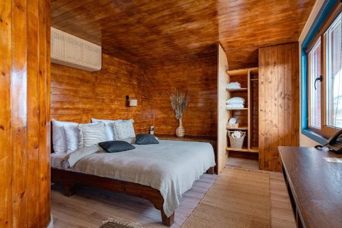 a bedroom with a bed in a wooden room at Razelm Luxury Resort in Jurilovca