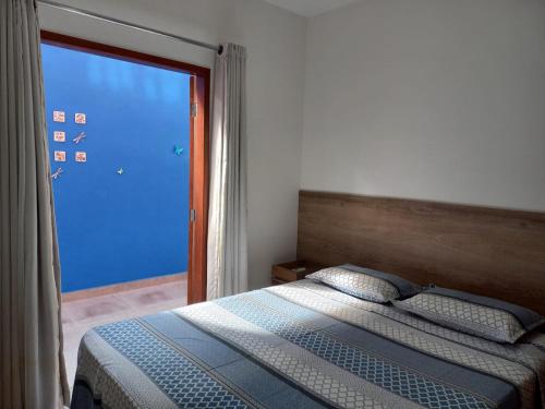 um quarto com uma cama e uma grande janela em Lindo Apartamento em Lençóis em Lençóis