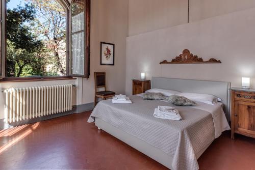 - une chambre avec un lit et une grande fenêtre dans l'établissement Appartamenti Villa Mascagni, à Volterra