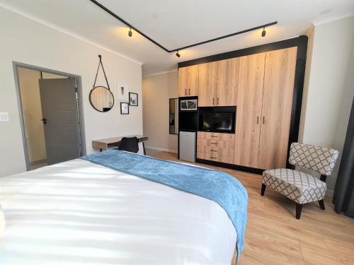 um quarto com uma cama, uma televisão e uma cadeira em MINT Hotel 84 on Katherine em Joanesburgo