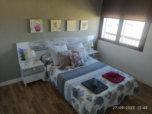 ein Schlafzimmer mit einem Bett und zwei Fenstern in der Unterkunft Piso Navas in Navas de San Antonio