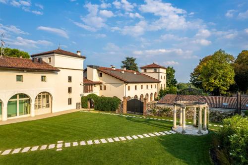 zewnętrzny widok na dom z trawnikiem w obiekcie Hotel Villa I Pini w mieście Malo